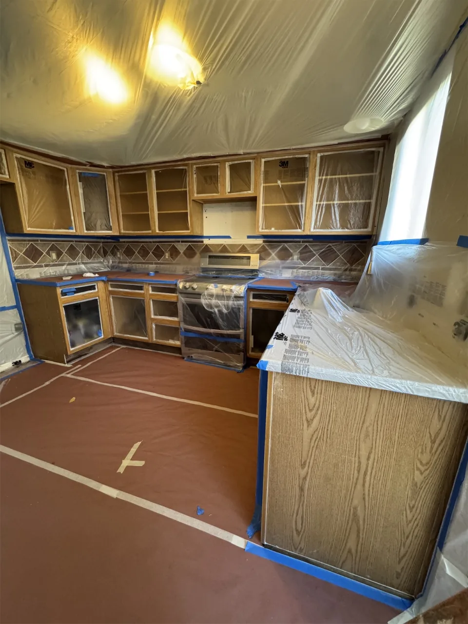 Cocina en pleno proceso de trabajo, con muebles desarmados y protecciones instaladas