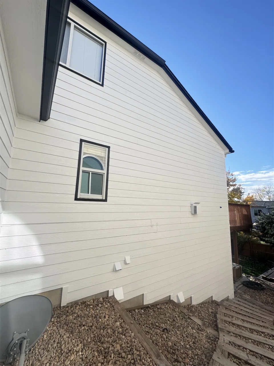 Revestimiento lateral de una casa con zonas reparadas y masilladas, listo para recibir pintura